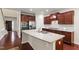 Open kitchen with a large island, granite countertops, stainless steel appliances, and dark wood cabinets at 1320 Cozy Oak Ave, Cary, NC 27519