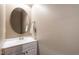Clean powder room featuring a white vanity, round mirror, and neutral wall paint at 1320 Cozy Oak Ave, Cary, NC 27519