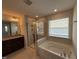 A bright bathroom featuring a shower, tub, and window at 14 Gallop Rein Cir, Benson, NC 27504