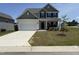 Charming two-story home featuring a manicured lawn and a spacious two-car garage at 14 Gallop Rein Cir, Benson, NC 27504