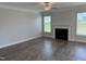 Open living area featuring laminate floors, a ceiling fan, and a cozy fireplace at 14 Gallop Rein Cir, Benson, NC 27504