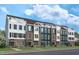 Modern townhouses featuring brick and siding, offering stylish urban living with rooftop patios at 1501 Village Hall Ln # 38, Wake Forest, NC 27587