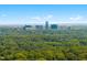 An aerial view showing a green landscape and a skyline of modern buildings under a blue sky at 1610 Ridge Rd, Raleigh, NC 27607