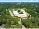 Aerial shot of a school campus surrounded by green trees in a suburban neighborhood at 1610 Ridge Rd, Raleigh, NC 27607