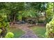 Lush backyard with stone pathway leading to seating area around a charming pond and waterfall feature at 1610 Ridge Rd, Raleigh, NC 27607