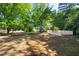 Expansive backyard with mature trees, a well-kept lawn, and a charming white picket fence surrounding a garden area at 1610 Ridge Rd, Raleigh, NC 27607