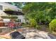 Stone patio with grill, dining area, and lush landscaping offers an ideal outdoor space at 1610 Ridge Rd, Raleigh, NC 27607