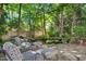 Serene backyard retreat featuring a tranquil pond with seating and lush landscaping at 1610 Ridge Rd, Raleigh, NC 27607