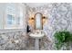Charming powder room with a pedestal sink, decorative wallpaper, and plantation shutters at 1610 Ridge Rd, Raleigh, NC 27607