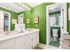 Bathroom with green walls, double vanity, and a separate toilet room at 1610 Ridge Rd, Raleigh, NC 27607