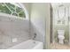 Bright bathroom with a window over tub and separate toilet room at 1610 Ridge Rd, Raleigh, NC 27607