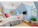 Bright bedroom features blue walls, a ceiling fan, and a large window at 1610 Ridge Rd, Raleigh, NC 27607