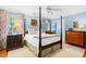 This is a luxurious bedroom with a four-poster bed, ceiling fan, floral curtains, and dark wood dressers at 1610 Ridge Rd, Raleigh, NC 27607