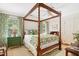 Cozy bedroom with four poster bed, green patterned bedding and curtains, and hardwood floors at 1610 Ridge Rd, Raleigh, NC 27607