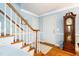 Bright and welcoming entryway with hardwood floors, staircase, and a grandfather clock at 1610 Ridge Rd, Raleigh, NC 27607