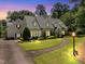 Charming two-story home boasts a lush lawn, beautiful landscaping, and inviting stone walkway at 1610 Ridge Rd, Raleigh, NC 27607