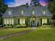 Inviting two-story home featuring dormer windows, a manicured lawn, and a stone pathway to the entrance at 1610 Ridge Rd, Raleigh, NC 27607