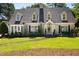 Classic two-story home with dormer windows, professional landscaping, and a stone pathway to the front door at 1610 Ridge Rd, Raleigh, NC 27607