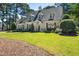 Inviting home with manicured lawn, dormer windows, and stone walkway leading to the entrance at 1610 Ridge Rd, Raleigh, NC 27607