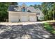 Spacious three-car garage with white doors and ample driveway space in a well-maintained home at 1610 Ridge Rd, Raleigh, NC 27607