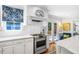 Stainless steel range in white kitchen with an eat-in seating area, and hardwood floors at 1610 Ridge Rd, Raleigh, NC 27607