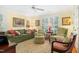 Cozy living room with a green sofa, patterned chairs, and bright natural light at 1610 Ridge Rd, Raleigh, NC 27607