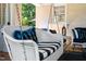Close-up of a charming white porch swing with black and white striped cushions at 1610 Ridge Rd, Raleigh, NC 27607