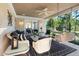 Inviting covered porch with white wicker seating, a ceiling fan, and views of the yard at 1610 Ridge Rd, Raleigh, NC 27607