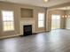 Open living space with fireplace, gray flooring, and sliding glass doors to backyard at 1618 Brownairs Ln, Raleigh, NC 27610