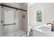 Bathroom featuring a glass-enclosed shower with tile and window at 1952 Lewis Dr, Burlington, NC 27215