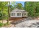 Exterior view of a charming home with white siding and dark shutters nestled among lush trees at 1952 Lewis Dr, Burlington, NC 27215