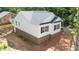 Side view of a new home with white siding, black shutters, a brick foundation, and a dark roof at 1952 Lewis Dr, Burlington, NC 27215