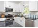 Close-up of a modern kitchen showcasing white cabinets, granite countertops, and stainless appliances at 1952 Lewis Dr, Burlington, NC 27215