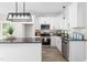 Modern kitchen featuring white cabinets, black countertops, stainless steel appliances, and stylish lighting at 1952 Lewis Dr, Burlington, NC 27215