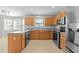 Bright kitchen featuring wood cabinets, stainless appliances and gray countertops at 2037 Summer Shire Way, Raleigh, NC 27604
