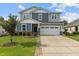 Charming two-story home with a two-car garage, well-manicured lawn, and beautiful landscaping at 209 S Harrison Place Ln, Fuquay Varina, NC 27526