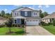 Inviting two-story home with a well-manicured lawn, showcasing its charming curb appeal and attached garage at 209 S Harrison Place Ln, Fuquay Varina, NC 27526