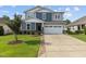 Attractive two-story home featuring a manicured lawn, beautiful landscaping, and a spacious driveway at 209 S Harrison Place Ln, Fuquay Varina, NC 27526