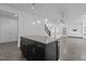 Kitchen island with stone countertop, dark cabinetry, and pendant lighting fixtures above at 209 S Harrison Place Ln, Fuquay Varina, NC 27526