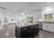 Kitchen island with dark cabinets, stone countertops, and pendant lights hanging above at 209 S Harrison Place Ln, Fuquay Varina, NC 27526