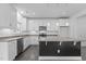 Stylish kitchen with white cabinets, quartz countertops, and a black island with bar seating at 209 S Harrison Place Ln, Fuquay Varina, NC 27526