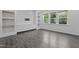 Bright living room featuring built-in shelves, cabinets, and large windows at 209 S Harrison Place Ln, Fuquay Varina, NC 27526