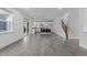 Bright living room features hard floors, white walls, and an open floor plan leading to the kitchen and stairs at 209 S Harrison Place Ln, Fuquay Varina, NC 27526
