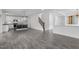Open-concept living space with hardwood floors, a staircase, and a kitchen area with white cabinets at 209 S Harrison Place Ln, Fuquay Varina, NC 27526