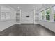 Bright living room featuring built-in shelves, cabinets, and large windows at 209 S Harrison Place Ln, Fuquay Varina, NC 27526