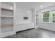 Living room features white shiplap accent wall with custom shelving and built-in cabinets at 209 S Harrison Place Ln, Fuquay Varina, NC 27526