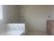 Bathroom featuring modern marble tile, a soaking tub and a walk-in shower, and wooden vanity at 216 Sprenger St, Garner, NC 27529
