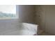 Bathroom featuring modern marble tile, a soaking tub and a walk-in shower, for a spa-like experience at 216 Sprenger St, Garner, NC 27529