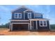Two-story home features a two-car garage, blue siding and white trim, enhancing its curb appeal at 216 Sprenger St, Garner, NC 27529