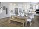 Contemporary white kitchen with stainless steel appliances, pendant lighting, and a wooden dining table at 216 Sprenger St, Garner, NC 27529
